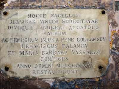 ...scoviamo una lastra in marmo con una scritta in latino datata 1874. Ricorda l�anno in cui i coniugi Francesco Falanga e Maria Barbara Vassallo restaurarono questa chiesa, dedicata alla Madonna dell�Odegitria e a Sant�Andrea Apostolo